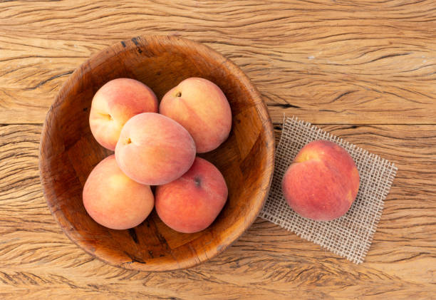 istock Peaches on a bowl over wooden table 1332584227