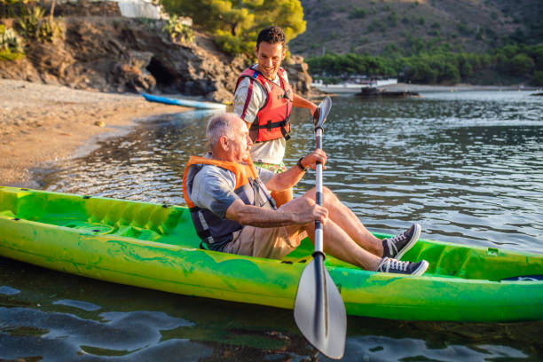 istock Male Kayakers Preparing to Push Off for Morning Paddle 1332586308