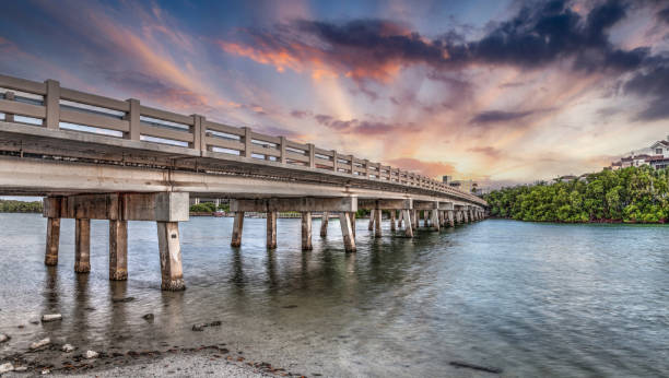 ciel de coucher de soleil sur le pont sur hickory pass menant à l’océan - bonita springs photos et images de collection