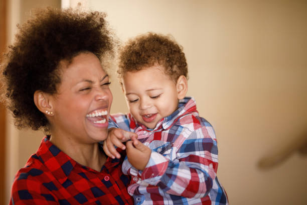 istock Mother laughing and holding her child on her lap 1332588695