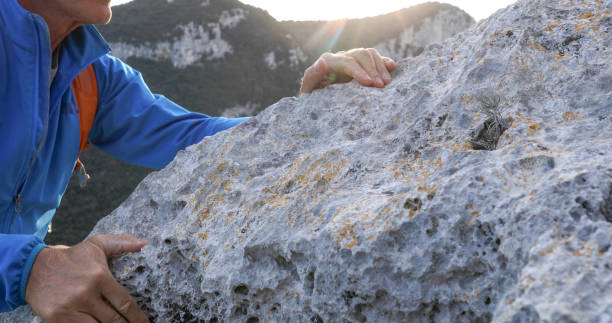 istock Mountaineer climbs up mountain ridge at sunrise 1332590145