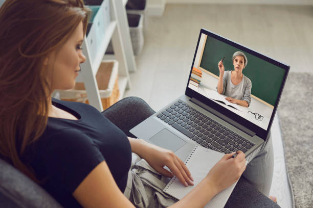 istock Online education. A girl teaches a lecture using a video lesson a laptop conference with a teacher remotely at home 1332593072