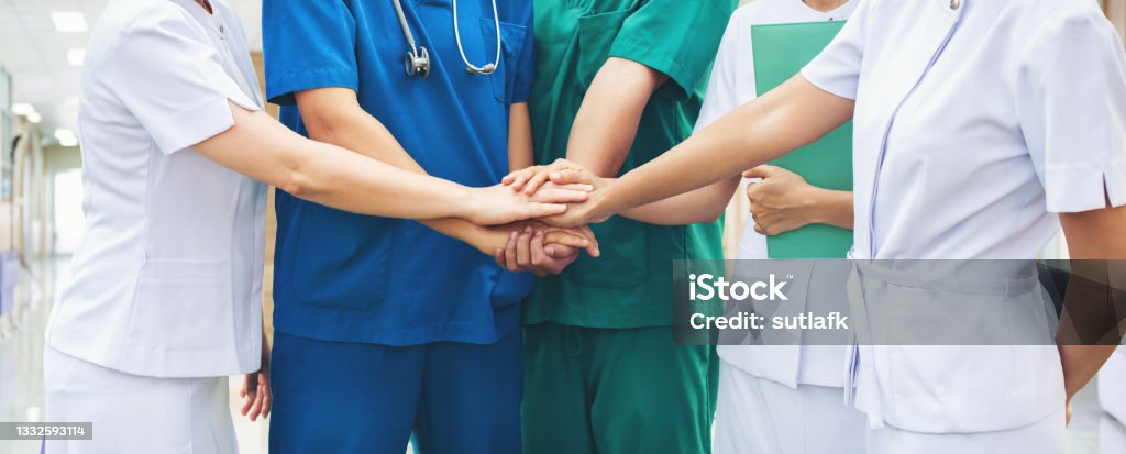 Cooperation of people in the medical community teamwork with a hands together Cooperation of people in the medical community teamwork with a hands together between the doctor in the green, blue uniform and nurses in white dress at hospital. Fight covid 19 virus healthy concept. Healthcare And Medicine Stock Photo