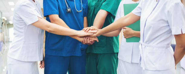 Cooperation of people in the medical community teamwork with a hands together Cooperation of people in the medical community teamwork with a hands together between the doctor in the green, blue uniform and nurses in white dress at hospital. Fight covid 19 virus healthy concept. medical occupation stock pictures, royalty-free photos & images