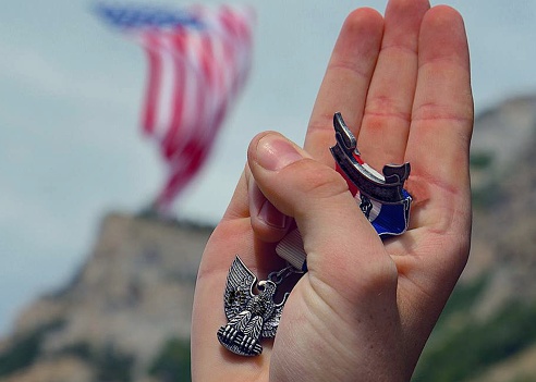 Young adult male hand in Boy Scout oath, Eagle Scout rank
