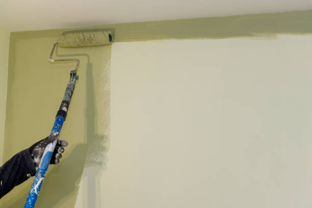 istock Worker painting on surface wall by the roller brush painting 1332595703