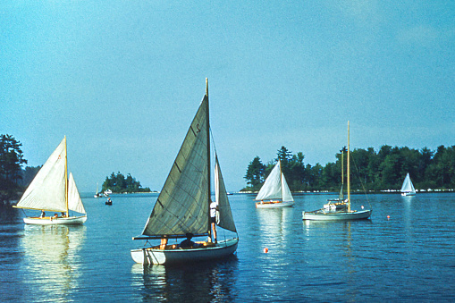 Sailing in small sailboats on a lake at summer camp. Maine 1948. Scanned film with significant grain.