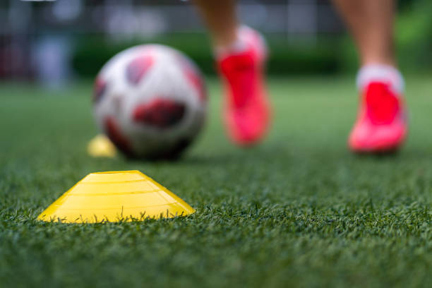 istock A yellow obstacle cone on ground with sport training action as blurred background. 1332602737