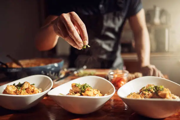 Photo of Shot of an unrecognisable man preparing a delicious meal at home