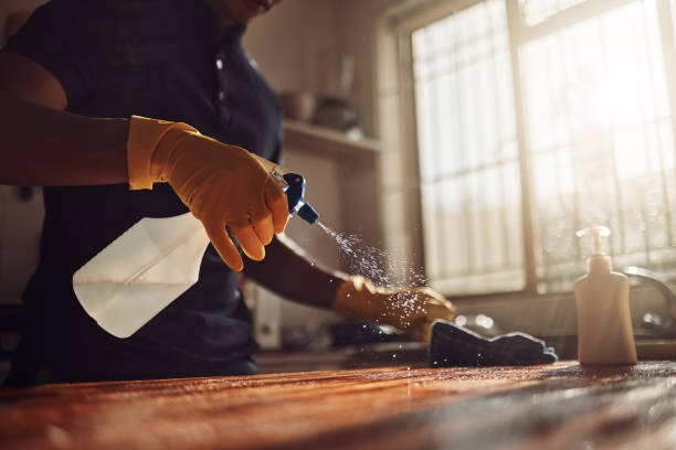 aufnahme eines nicht wiederzuerkennenden mannes, der zu hause eine küchentheke desinfiziert - lifestyles domestic kitchen human hand furniture stock-fotos und bilder
