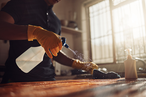 Foto de un hombre irreconocible desinfectando una encimera de cocina en casa photo