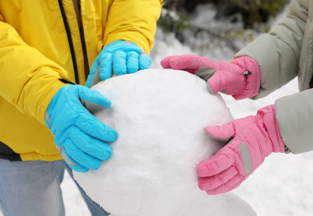 istock People making snowman outdoors, closeup. Winter vacation 1332615665