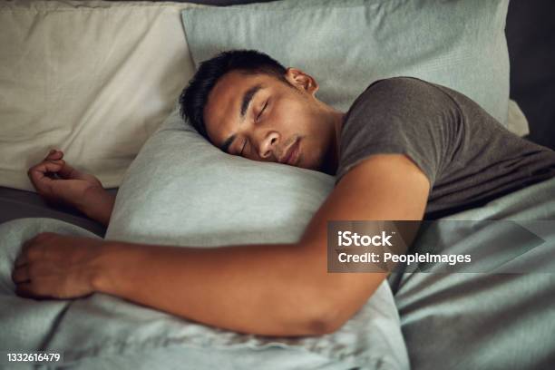 Shot Of A Young Man Sleeping Peacefully In Bed At Home Stock Photo - Download Image Now