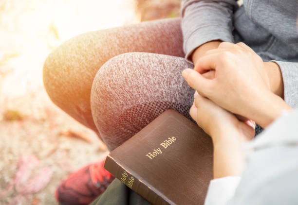 Two women hold hands and pray as they study the bible. Christian concept. Two women hold hands and pray as they study the bible. Christian concept. christian social union photos stock pictures, royalty-free photos & images