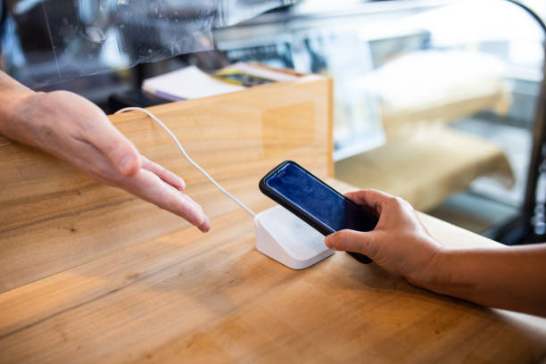 istock Staff hand showing reader for cashless payment by mobile phone at a cafe 1332623025