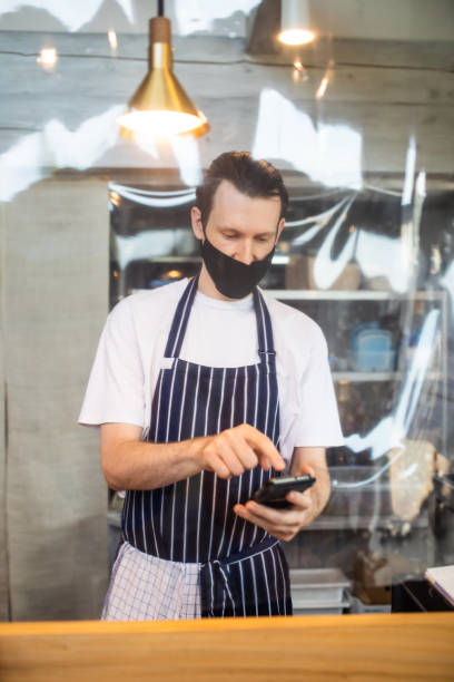 istock Male cafe staff taking an order on his mobile phone 1332623031