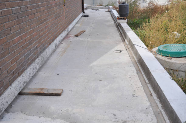 istock Backyards ideas. Constructing a concrete walkway along the backside of the house not far from a sewage septic tank. 1332629797