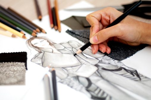 Fashion designer is drawing an artistic fashion sketch ,close-up photo