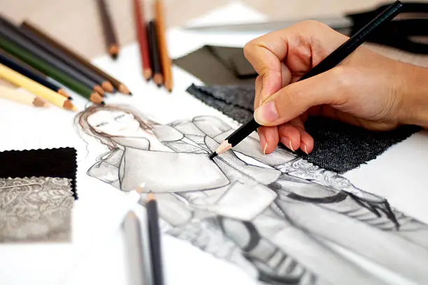 Fashion designer is drawing an artistic fashion sketch ,close-up photo
