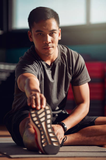 istock Shot of a young man stretching his legs before a workout 1332633740