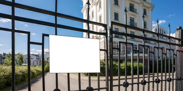 istock Blank white information sign board hangs on black metal fence 1332634923
