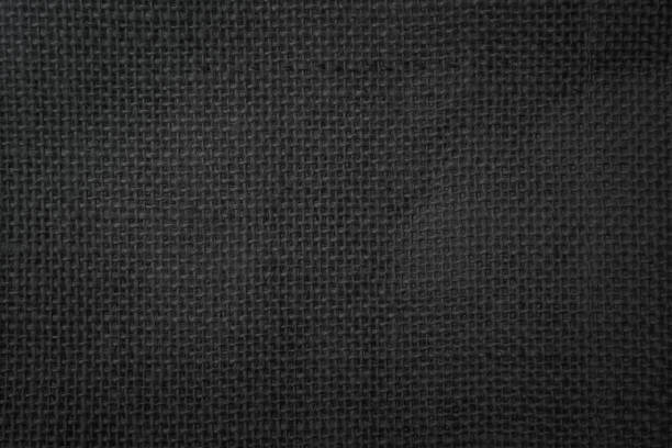 istock Jute hessian sackcloth canvas woven texture pattern background in light black color blank empty. 1332635011