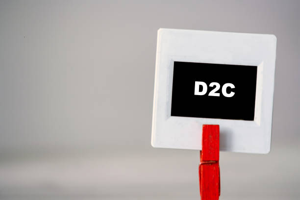 istock Plastic frame with clothes pin on table. White frame with black background and inscription word D2C idea 1332637899