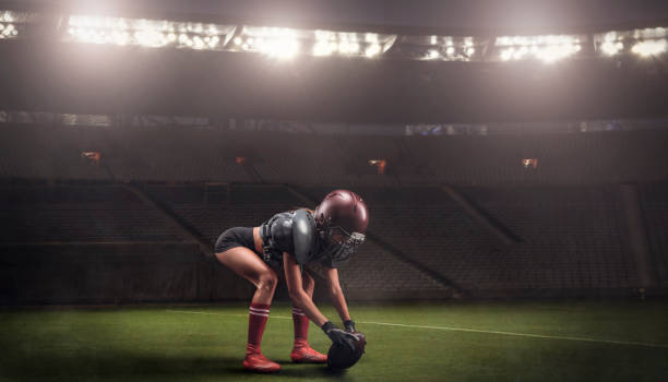 スタジアムでボールをプレーする準備をしているアメリカンフットボールチームの選手のユニフォームを着た女の子のイメージ。スポーツコンセプト。 - football player american football sports team teamwork ストックフォトと画像