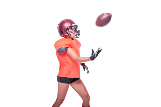 アメリカンフットボールチームの選手のユニフォームを着た女性がボールをキャッチします。白い背景。スポーツコンセプト。 - football player american football sports team teamwork ストックフォトと画像