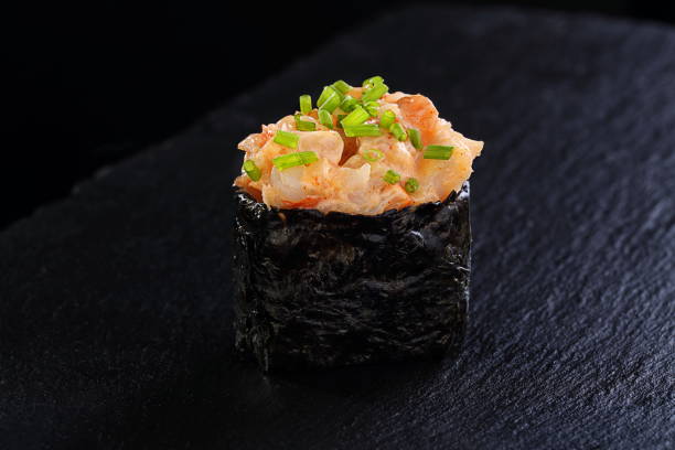istock Rolls with red caviar on a black background 1332641695