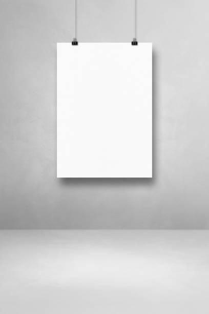 istock White poster hanging on a light concrete wall with clips 1332644005