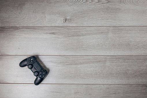 Video game joystick on the wooden background