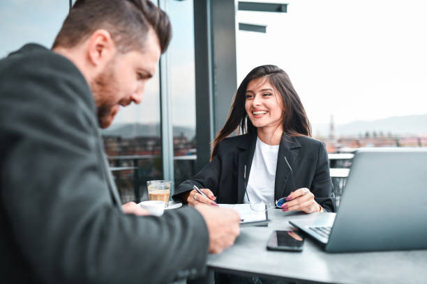 istock Smiling Secretary Presenting New Project Plan For CEO During Balcony Meeting 1332647961