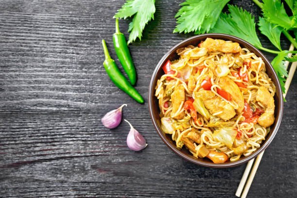 istock Noodles with cabbage and chicken in bowl on dark board top 1332648990