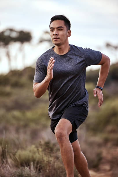 shot of a young man exercising in nature - evento de pista imagens e fotografias de stock