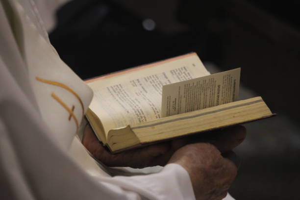 istock Priest holding an open Bible and praying 1332654348
