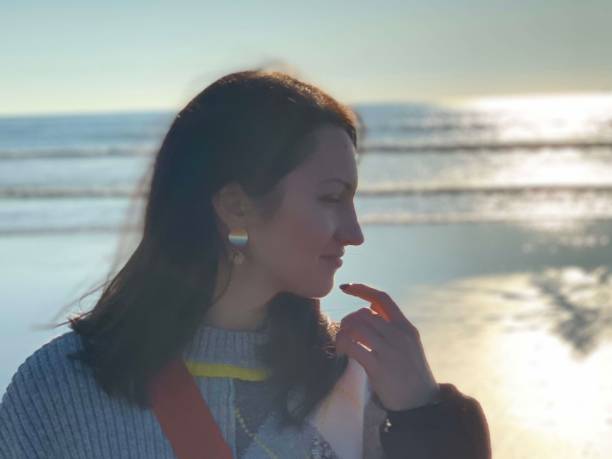 istock Young millennial woman by the ocean. 1332654823
