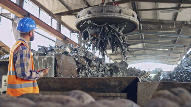 Man supervising the scrap magnet at the recycling facility