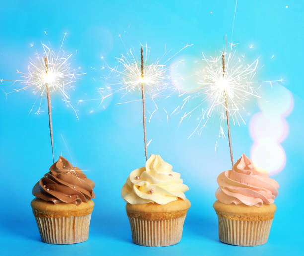 istock Birthday cupcakes with sparklers on light blue background 1332654852