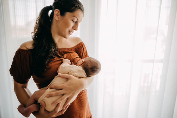 Mother breastfeeding her newborn son stock photo