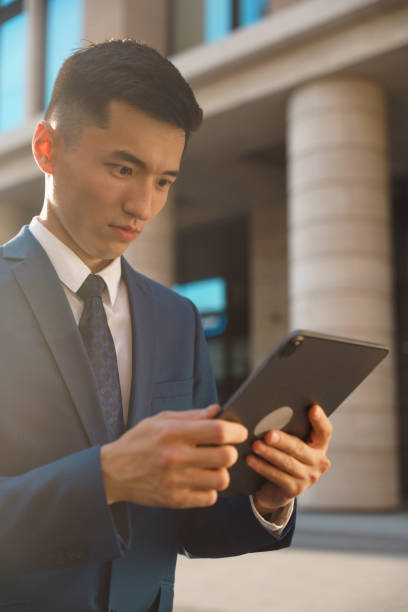istock A young asian manager in a blue suit is surprised by an email he got on his tablet 1332656481