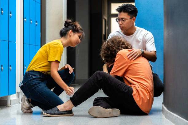 Two teen asian high school students comfort sad and depressed classmate victim of bullying in corridor. Two teen asian high school students comfort sad and depressed classmate victim of bullying in corridor. Bullying concept. Togetherness. victim advocacy stock pictures, royalty-free photos & images