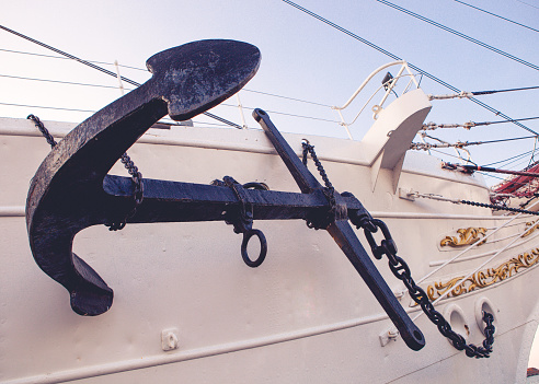 The white anchor with black stripes on a black background. Anchor concept. 3D render.