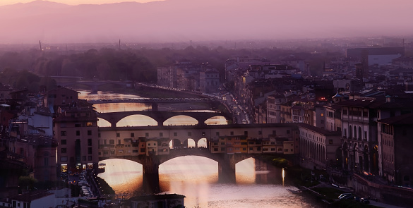 Panoramic view with sunbeam at medieval stone bridge Ponte Vecchio and the Arno River from the Ponte Santa Trinita (Holy Trinity Bridge) in Florence, Tuscany, Italy