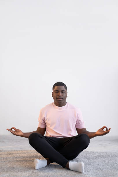 istock yoga practice calm black man home training 1332659361