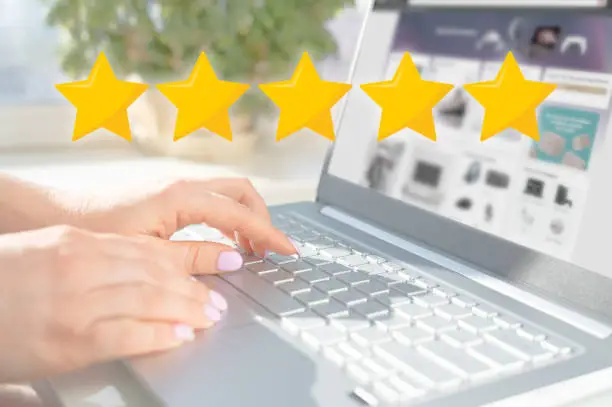 Photo of five star rating. Rise on increasing five stars in human hand, Increase rating evaluation classification concept. Woman hand using laptop with icon five star symbol to increase rating company concept