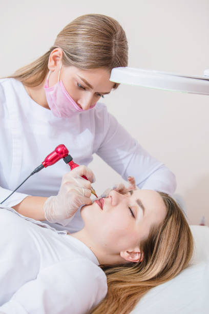 kosmetikerin macht permanent make-up der lippen einer jungen patientin im büro - lipstick russian ethnicity fashion model fashion stock-fotos und bilder
