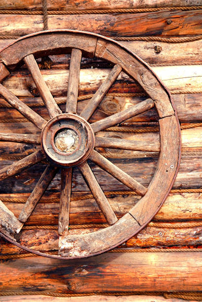 istock Old wooden wagon wheel on the log cabin wall 1332664726