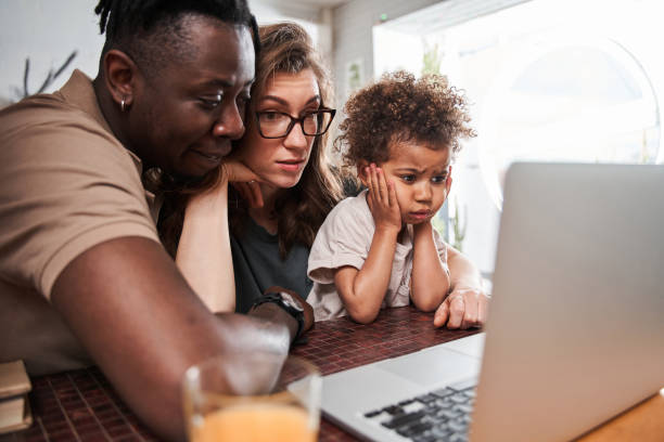 istock Girl feeling shocked while watching something at the laptop with her diverse parents 1332666964