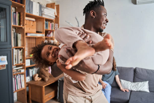 istock Father holding at the hands his little multiracial daughter while spending time together 1332666998